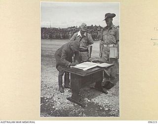 CAPE WOM, NEW GUINEA, 1945-09-13. LIEUTENANT-GENERAL ADACHI, COMMANDER 18 JAPANESE ARMY IN NEW GUINEA, SIGNING THE INSTRUMENT OF SURRENDER. HE ACCEPTED THE TERMS UNCONDITIONALLY. LIEUTENANT-GENERAL ..