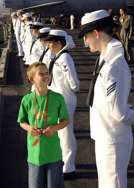 060729-N-7981E-063 (Jul. 29, 2006)US Navy (USN) Storekeeper SEAMAN (SKSA) Buckingham chats with her Tiger while she and other Sailors from the USN Nimitz Class Aircraft Carrier USS ABRAHAM LINCOLN (CVN 72) man the rails as they depart Naval Station (NS) Pearl Harbor, Hawaii (HI), during a Tiger Cruise in the Pacific Ocean (POC). Tiger Cruise is provided for family members and friends of the crew to give them an opportunity to experience life at sea for a week.U.S. Navy photo by Mass Communication SPECIALIST SEAMAN James R. Evans (RELEASED)