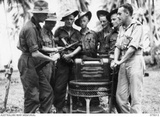 MILILAT, NEW GUINEA. 1944-08-01. PERSONNEL OF THE FIELD SECURITY SECTION, HEADQUARTERS, 5 DIVISION WITH A GERMAN SLOTHERN SUB-MACHINE GUN AND A SAMURAI SWORD CAPTURED FROM THE JAPANESE AT HANSA ..