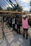 Young men lash thatch panels