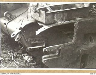 SCARLET BEACH AREA, NEW GUINEA. 1943-12-21. DAMAGED NEAR SIDE IDLER AND SPONSON CUT AWAY ON A MATILDA TANK AT THE 1ST AUSTRALIAN TANK BATTALION GROUP WORKSHOP, AUSTRALIAN ELECTRICAL AND MECHANICAL ..