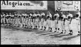 [Members of the baseball team stand at attention during the playing of the Mexican and United States national anthems before a game in Mexico City, 1965]