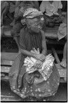 Mortuary ceremony: mourning woman with banana leaf bundles, she wears a cloth skirt