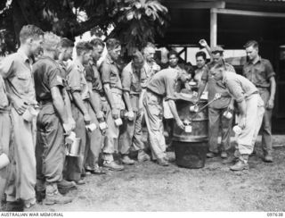 NAURU ISLAND. 1945-10-02. FOLLOWING THE SURRENDER OF THE JAPANESE, TROOPS OF 31/51 INFANTRY BATTALION OCCUPIED THE ISLAND. SHOWN, PRIVATE M. BARRIE DISHING OUT MORNING TEA TO MEMBERS OF D COMPANY