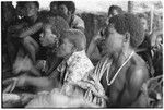 Women beating leaf packets in accompaniment of 'aubinubinu panpiping