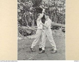 LAE, NEW GUINEA. 1944-09-21. CORPORAL J.L. LEYS (1) AND SERGEANT A.J. DENSMORE (2) OF THE NEW GUINEA FORCE PROVOST COMPANY PRACTICING UNARMED COMBAT