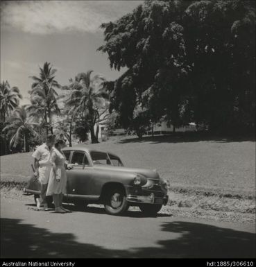 Tennis player standing by car