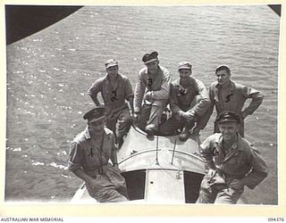 TOL, NEW BRITAIN. 1945-07-26. PILOTS AND CREW OF ROYAL NEW ZEALAND AIR FORCE SEACATS CATALINA SITTING ON THE NOSE OF THE PLANE WATCHING MOVEMENT ON SHORE AT TOL PLANTATION. IDENTIFIED PERSONNEL ..