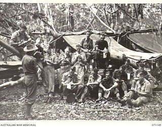 FORTIFICATION POINT, NEW GUINEA, 1944-03-15. OFFICER COMMANDING 32ND FIELD SECURITY SECTION, INTELLIGENCE CORPS, SX20816 CAPTAIN D.E. MIELL (1), PICTURED REVIEWING RECENT OPERATIONS IN A TALK TO ..