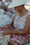 Plaiting kaukie (processed fibres from young coconut frond) around a coconut shell