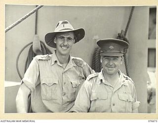 JACQUINOT BAY, NEW BRITAIN. 1944-11-04. TX5216 LIEUTENANT H.C. TAYLOR (1) AND VX14904 CAPTAIN F. BOLAND (2) OFFICERS OF THE 33RD DOCKS OPERATING COMPANY SUPERVISING THE UNLOADING OF THE EQUIPMENT ..