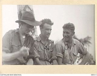 SUAIN PLANTATION, NEW GUINEA. 1944-12-08. PRIVATE J.J. NOLAN, A COMPANY, 2/4 INFANTRY BATTALION, (1), IN DISCUSSION WITH FLYING OFFICER D.F. NOLAN, (2), AND WARRANT OFFICER J.W. HAMILTON, (3), ..