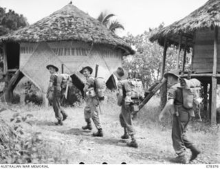 WIDE BAY, NEW BRITAIN. 1945-01-16. PERSONNEL OF "A" COMPANY, 14/32ND INFANTRY BATTALION ENTERING KALAMPUN VILLAGE AFTER THEIR MARCH FROM SAMPUN. IDENTIFIED PERSONNEL ARE:- VX70092 PRIVATE L.G. ..