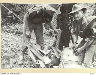 1943-09-28. NEW GUINEA. ADVANCE ON SALAMAUA. AUSTRALIANS EXAMINING THOUSANDS OF ROUNDS OF JAPANESE AMMUNITION CAPTURED DURING THE ADVANCE ON SALAMAUA. THIS 7.7MM AMMUNITION IN METAL STRIPS OF 30 ..