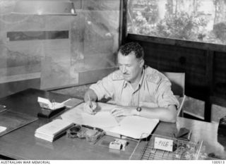 New Guinea. 1944-06-17. An informal portrait of Brigadier A. R. Garrett, Brigadier General Staff, Headquarters New Guinea Force, working in his office