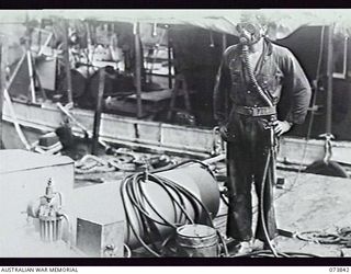 LABU, NEW GUINEA. 1944-06-17. NX98859 CRAFTSMAN C. HOLLOWAY, 1ST WATERCRAFT WORKSHOP, AUSTRALIAN ELECTRICAL AND MECHANICAL ENGINEERS, WEARING IMPROVISED DIVING GEAR WHICH UTILISES THE STANDARD ..