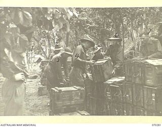 DUMPU, RAMU VALLEY, NEW GUINEA, 1944-02-11. 57/60TH INFANTRY BATTALION MEMBERS STACKING A RESERVE STOCK OF AMMUNITION FOR THE NEXT ACTION. IDENTIFIED PERSONNEL ARE: VX141781 PRIVATE T. POWER (1); ..