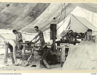 ALEXISHAFEN, NEW GUINEA. 1944-09-13. CARPENTERS AND TEXTILE WORKERS OF THE 133RD BRIGADE WORKSHOPS BUSY IN THEIR TENT WORKSHOP. IDENTIFIED PERSONNEL ARE:- N456872 CORPORAL A.L. MCGEORGE (1); ..