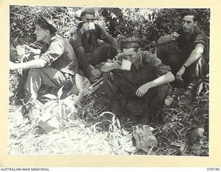 BOUGAINVILLE ISLAND. 1945-02-17. TROOPS OF THE 61ST INFANTRY BATTALION RELAXING WHILE ENJOYING A CUP OF TEA AT MEIVO JUNCTION AFTER THEIR ADVANCE FROM MARERI RIVER TO LINK UP WITH THE 9TH INFANTRY ..