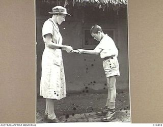 1943-03-15. NEW GUINEA. IN THE MANNER OF THE JAPANESE BILL BOWS TO SISTER VIDA DRYSDALE OF WEST WALLSEND N.S.W. WHEN SHE GAVE HIM SOME LOLLIES. (NEGATIVE BY BOTTOMLEY & BROWN)