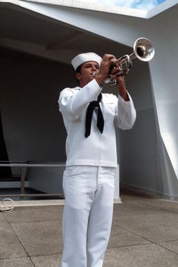 A bugler plays taps as the remains of a crew member of the battleship USS ARIZONA (BB 39) are committed to the sunken vessel during a memorial service at the USS ARIZONA memorial. The remains, stored in a canister, will be dropped into an opening in the battleship's submerged hull