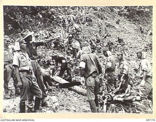 RABAUL, NEW BRITAIN. 1945-09-25. JAPANESE WORKING PARTY, WORKING UNDER B SECTION, 11 DIVISION SIGNALS, CLEARING A PATH THROUGH THE JUNGLE FOR THE ERECTION OF SIGNAL LINES
