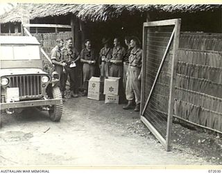 MILNE BAY, NEW GUINEA. 1944-04-04. VX106010 CORPORAL T.R. MORGAN (5), AND V32181 PRIVATE R. DE C. TRONSON (6), MEMBERS OF THE AUSTRALIAN COMFORTS FUND BULK STORES ISSUING A THREE MONTHS SUPPLY OF ..