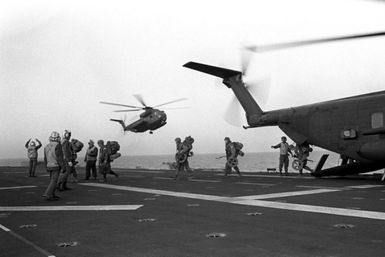 Marines exit from a CH-53 Sea Stallion helicopter aboard the amphibious assault ship USS GUAM (LPH 9), as the 22nd Marine Amphibious Unit redeploys from Beirut at the conclusion of a multinational peacekeeping operation