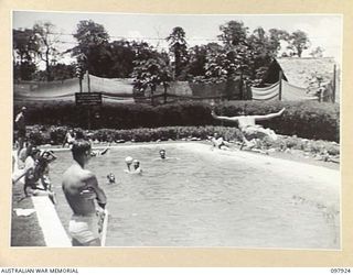 LAE, NEW GUINEA. 1945-10-20. AUSTRALIAN WOMEN'S ARMY SERVICE AND TROOPS OF FIRST ARMY ENJOYING A DIP IN THE AUSTRALIAN NEW GUINEA ADMINISTRATIVE UNIT SWIMMING POOL. WATER FOR THE POOL IS SUPPLIED ..