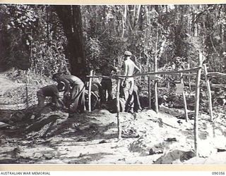 BOUGAINVILLE. 1945-04-05. PADRE AND TROOPS BURYING A 25 INFANTRY BATTALION SOLDIER KILLED DURING ACTION ON SLATER'S KNOLL. MOPPING UP OPERATIONS CONTINUED ON THE OTHER SIDE OF THE KNOLL