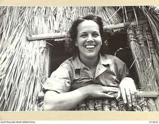 1942-11-23. UNITED STATES NURSES IN NEW GUINEA. JUANITA HAMILTON OF HENDERSONVILLE, N.C. LOOKING OUT FROM THE WINDOW OF HER NEW HOME IN NEW GUINEA. (NEGATIVE BY BOTTOMLEY)