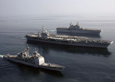 (From bottom-to-top), Aerial starboard view of the U.S. Navy Ticonderoga Class Guided Missile Cruiser USS ANZIO (CG 68), the Nimitz Class Aircraft Carrier USS DWIGHT D. EISENHOWER (CVN 69), and the Tarawa Class Amphibious Assault Ship USS SAIPAN (LHA 2), as they sail in formation during a photographic exercise in the Arabian Sea on Nov. 20, 2006. The ships are currently deployed in support of maritime security operations in the region. (U.S. Navy photo by Mass Communication SPECIALIST SEAMAN Patrick W. Mullen III) (Released)