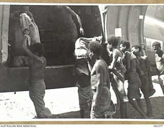 DUMPU, NEW GUINEA. 1943-12-19. SOME OF THE 500 BAGS OF MAIL FOR THE AUSTRALIAN TROOPS IN THE AREA BEING UNLOADED FROM AIRCRAFT AT THE DUMPU AIRSTRIP