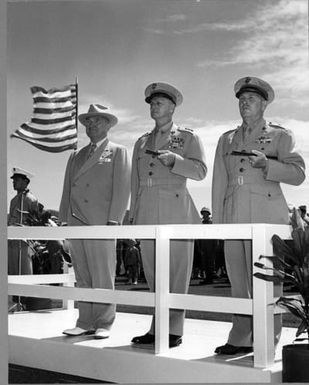 Former President Harry S. Truman stands on a viewing stage with two Marines at the commissioning ceremony at the Marine Corps Air Station, Kaneohe Bay, Hawaii