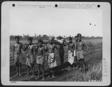 Natives bearing wounded American troops behind the lines at Buna, Papua New Guinea. (U.S. Air Force Number 23263AC)