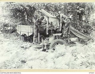 HANSA BAY, NEW GUINEA. 1944-06-22. N271636 PRIVATE D. W. SHOBLON (1) AND WX40058 PRIVATE L. C. JARVIS (2) OF THE 4TH INFANTRY BATTALION EXAMINING AN ABANDONED 75MM JAPANESE FIELD ANTI-AIRCRAFT GUN ..