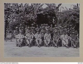 TOROKINA, BOUGAINVILLE, 1945-04-22. MAJ-GEN C.H. SIMPSON, SIGNAL OFFICER- IN- CHIEF (4), WITH GROUP OF OFFICERS AT HQ B CORPS SIGNALS. THE FRONT ROW INCLUDES MEMBERS OF THE GENERAL'S PARTY. (FOR ..