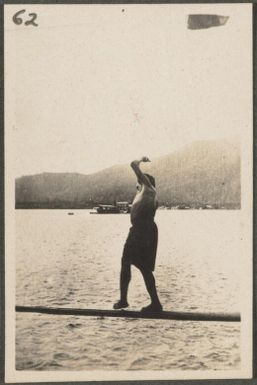 Papuan man trying to walk to end of pole before falling, Rabaul, New Britain Island, Papua New Guinea, approximately 1916, 1