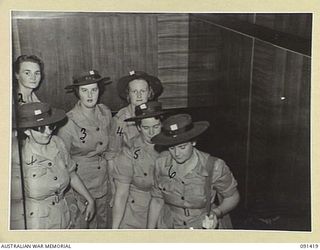 LAE, NEW GUINEA, 1945-05-07. AUSTRALIAN WOMEN'S ARMY SERVICE (AWAS) MEMBERS FILING UP THE SHIP'S GANGWAY FOR DISEMBARKATION INTO LANDING BARGES. THEY ARE PART OF A GROUP OF 342 AWAS FROM AUSTRALIA ..