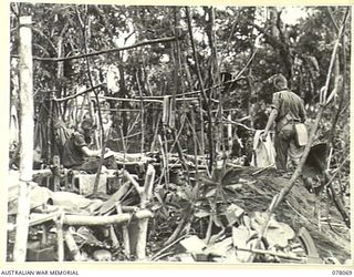 DANMAP RIVER AREA, NEW GUINEA. 1945-01-01. A SECTION OF THE JUNGLE CAMP AREA OF THE 2/3RD FIELD REGIMENT. IDENTIFIED PERSONNEL IS:- SX2839 LIEUTENANT R.A. RINGWOOD (1)