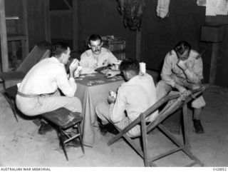 TROBRIAND ISLANDS, PAPUA. C. 1944-03. AIRCREW OF NO. 30 (BEAUFIGHTER) SQUADRON RAAF RELAX IN THE MESS AT KIRIWINA, PLAYING CARDS AND READING