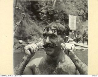 ZENAG, NEW GUINEA, 1944-02-27. NX10259, SAPPER L. COOK (1), OF THE 2/9TH FIELD COMPANY, ROYAL AUSTRALIAN ENGINEERS, PICTURED WITH A MOUSTACHE WHICH TOOK 5 MONTHS CULTIVATION