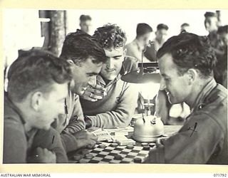 WAREO, PAPUA, NEW GUINEA, 1944-03-29. MEMBERS FROM THE 37/52ND INFANTRY BATTALION PLAY A GAME OF DRAUGHTS UNDER THE LIGHT OF A TILLEY LAMP AT B COMPANY, 4TH FIELD AMBULANCE REST CAMP. LEFT TO ..