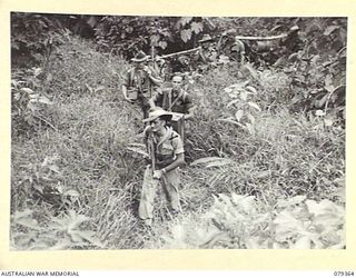 LAE, NEW GUINEA. 1945-03-11. TROOPS OF THE NEW GUINEA SCHOOL OF SIGNALS TRANSPORTING A WS22 SET DURING A DEMONSTRATION EXERCISE