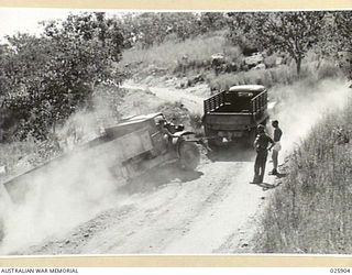 PORT MORESBY, PAPUA. 1942-07-15. AN AUSTRALIAN ARMY TRUCK IN DIFFICULTY ON ONE OF THE NARROW ROADS IN THE HILLY COUNTRY OF NEW GUINEA. THE VEHICLE HAD GONE OFF THE EDGE OF THE ROAD