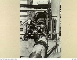 PORT MORESBY, PAPUA, 1944-03-21. THE OIL PIPELINE AND DISCHARGE VALVE FROM THE OIL TANKER EMPIRE SILVER, PICTURING NX142510 CORPORAL G.A. JEFFRY OF THE 1ST BULK PETROLEUM STORAGE COMPANY WORKING ON ..
