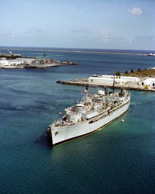 A harbor tugs positions the submarine tender USS PROTEUS (AS 19) in Apra Harbor