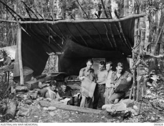 NEW GUINEA. 1943-11-28. INTELLIGENCE OFFICE, HEADQUARTERS, 24TH AUSTRALIAN INFANTRY BRIGADE. SHOWN ARE LEFT TO RIGHT: WX4426 STAFF SERGEANT J. A. ELLIS; VX12569 CORPORAL J. E. DIXON; WX3719 CAPTAIN ..