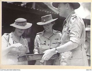 LORD WAKEHURST, GOVERNOR OF NEW SOUTH WALES (3), WITH LADY WAKEHURST (2), AND LADY BLAMEY (1), AT HEADQUARTERS 4 INFANTRY BRIGADE SAMPLING A TRAY OF CAKES COOKED IN THE 4 INFANTRY BRIGADE KITCHEN