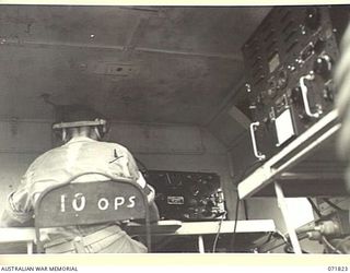 KATIKA, NEW GUINEA. 1944-03-31. NX65187 SIGNALMAN C. STRAHAN, B AUSTRALIAN CORPS SIGNALS, RECEIVING A MESSAGE FROM THE 188F, (UNITED STATES ARMY 191F), WIRELESS TRANSMITTER-RECEIVER. WHEN NOT IN ..